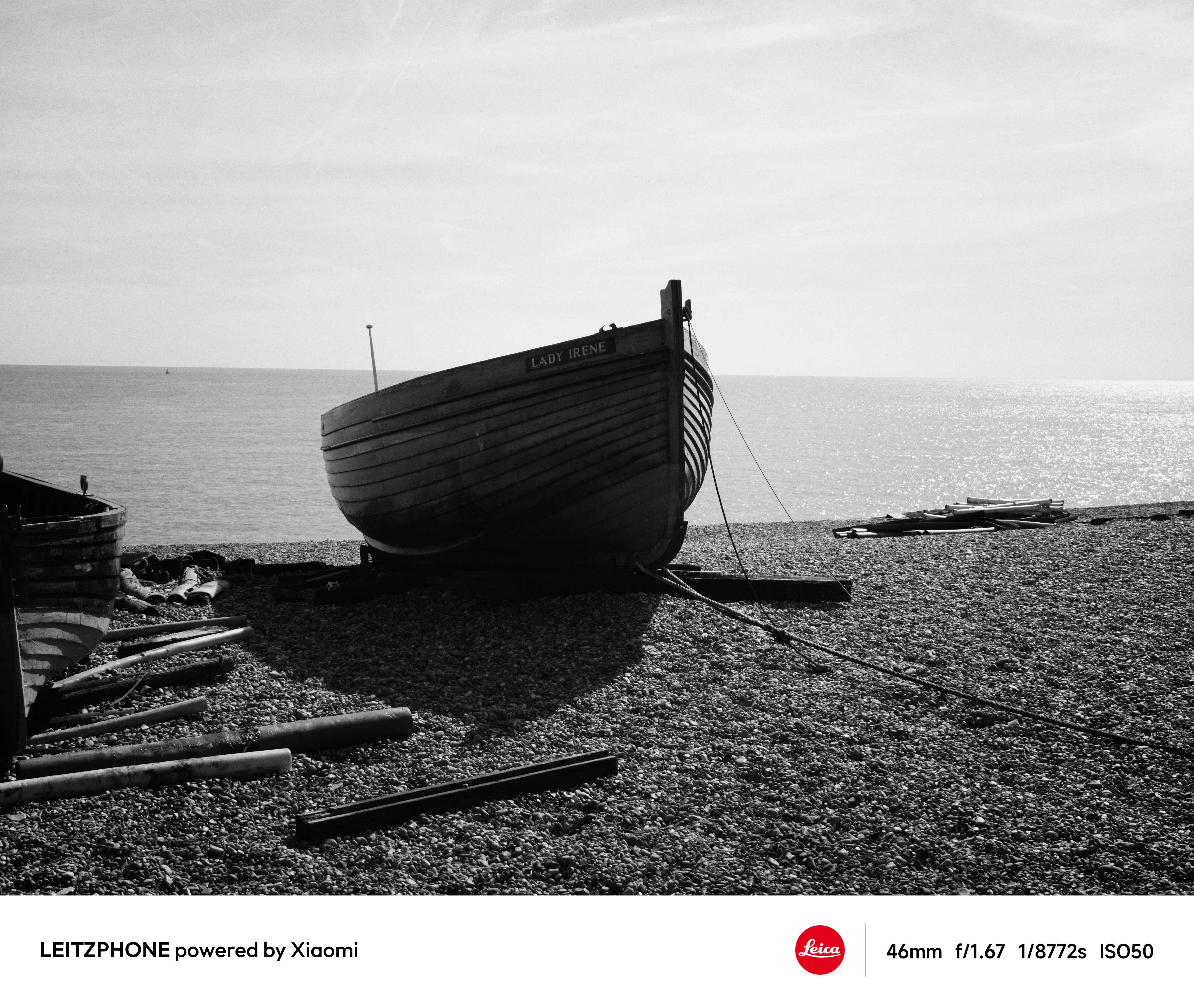 Black-and-white photo of a wooden boat by the sea