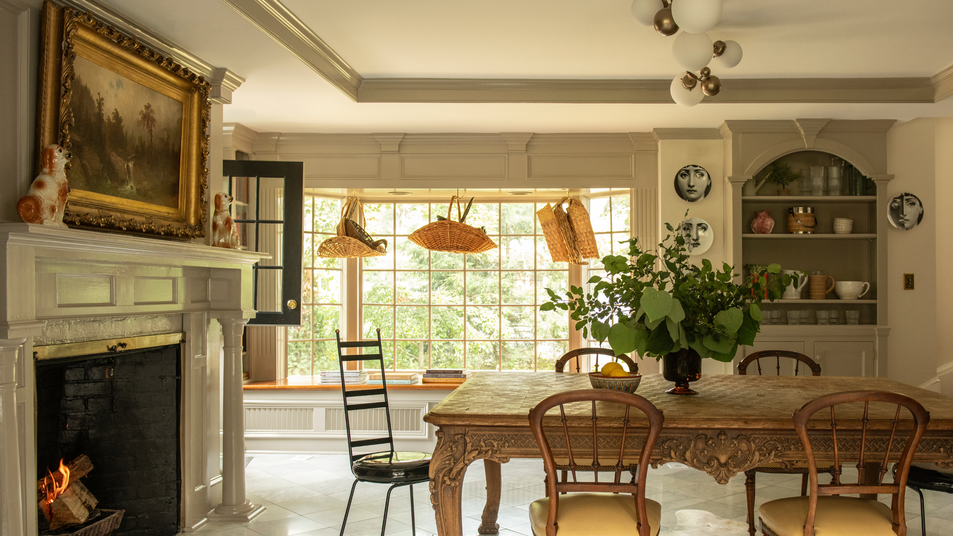 Eclectic, art-filled dining area featuring ornate antique furniture and tile floors