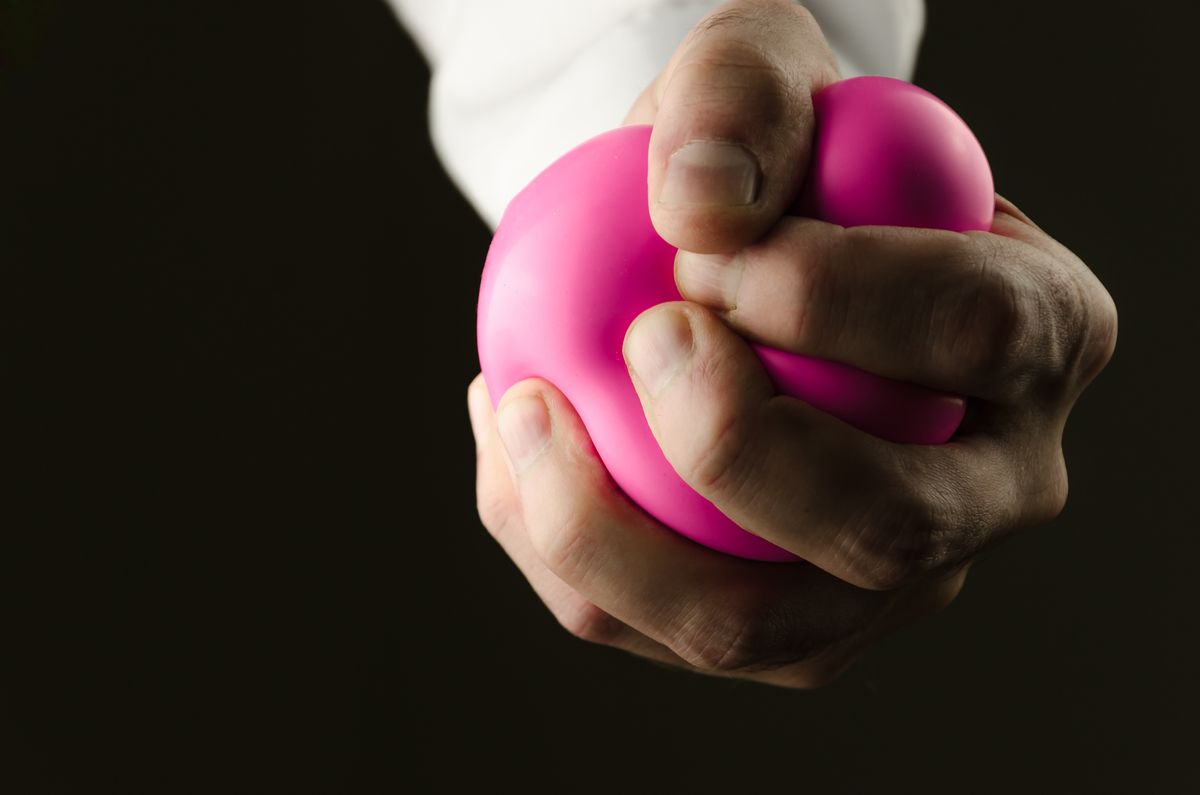 A man squeezing a stress ball.