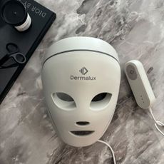 The Dermalux LED Face Mask on a marble table