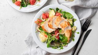 image shows a healthy meal of lean chicken with salad
