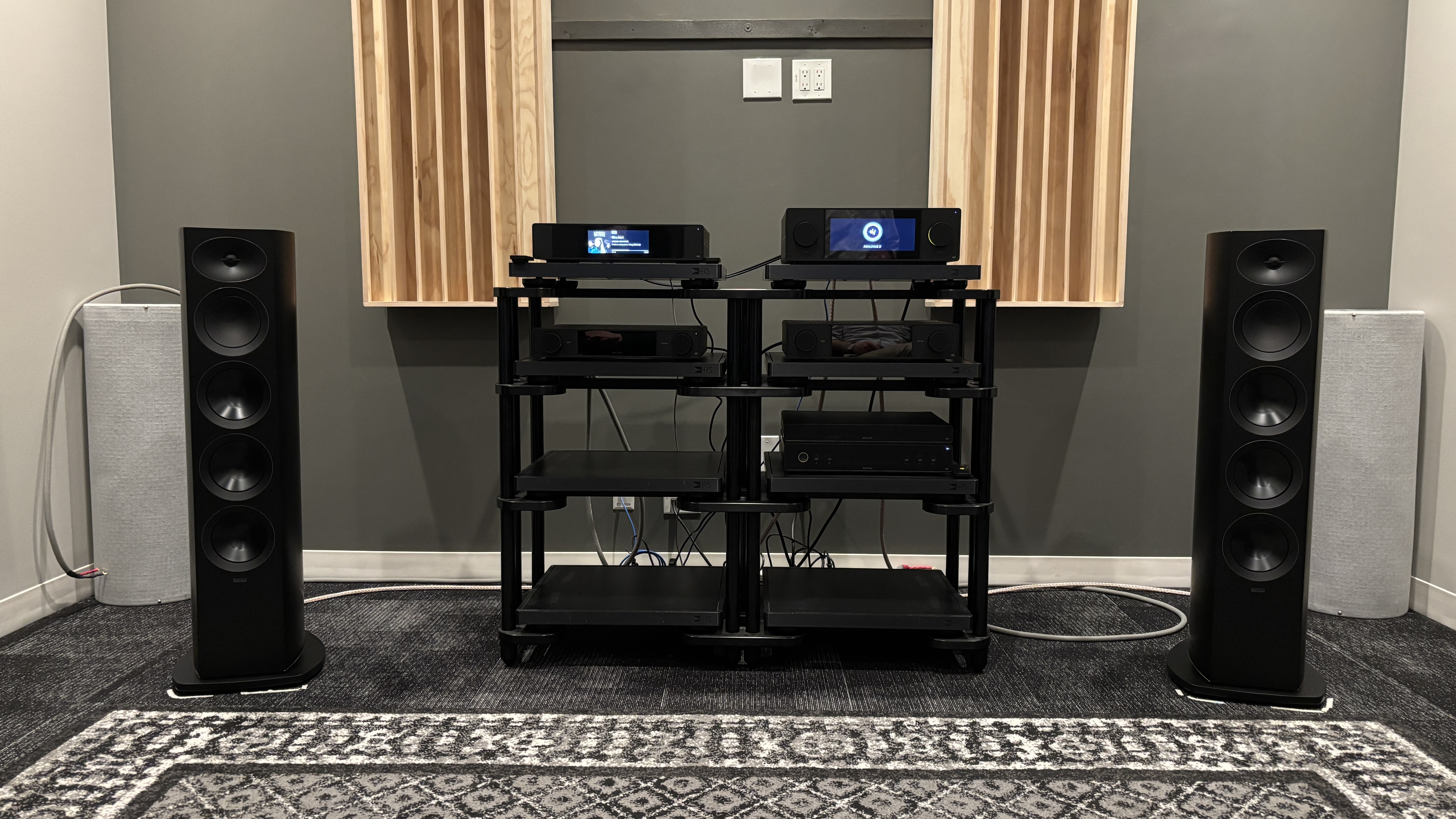 Arcam Radia R45 speakers in a listening room either side of a hi-fi rack with Arcam electronics