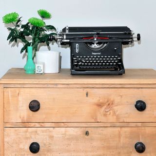 drawers with typewriter and flower vase