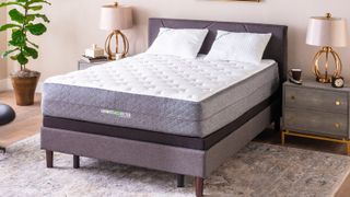The GhostBed Luxe Mattress shown on a grey and brown fabric bed frame in a stylish bedroom