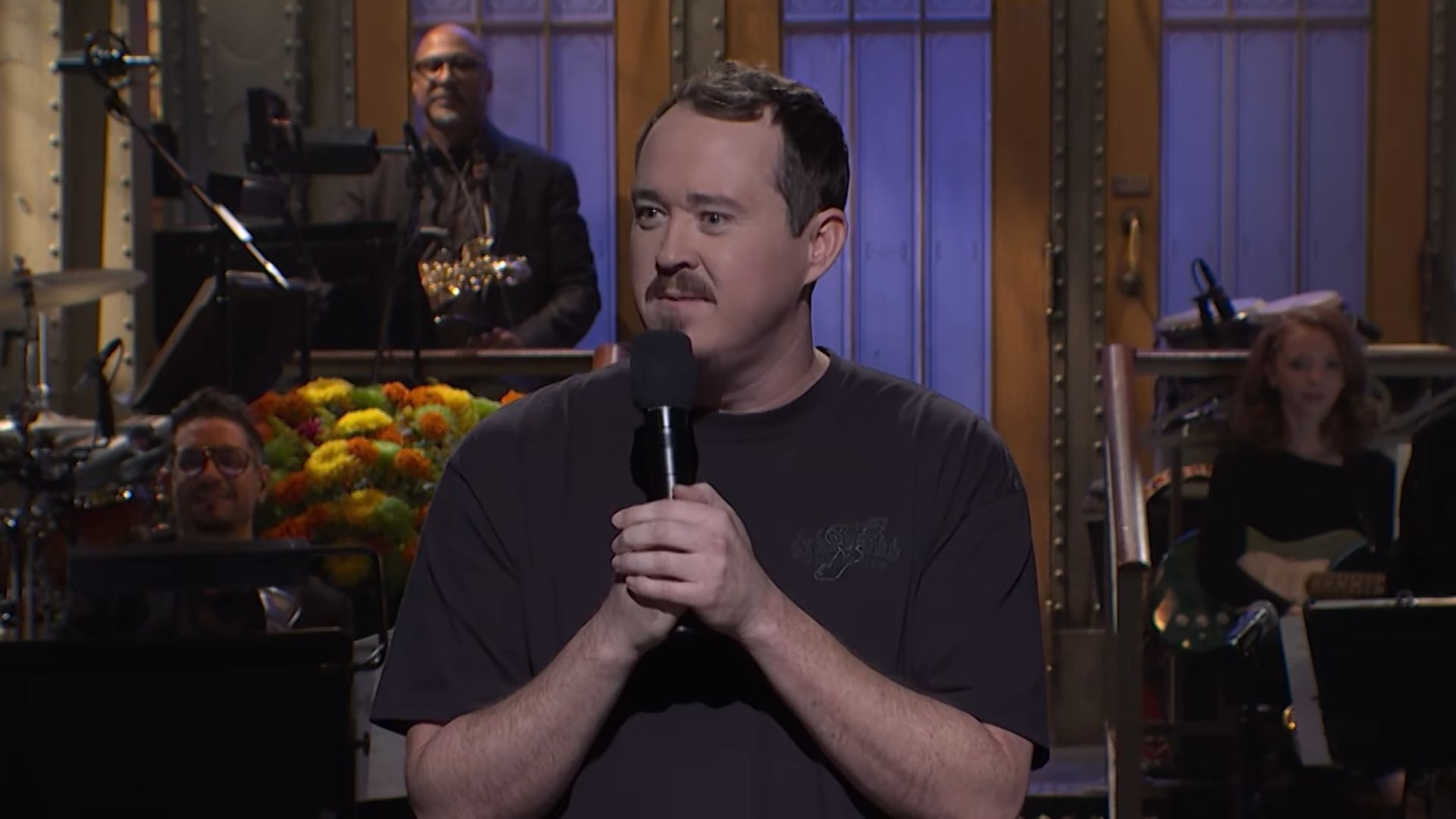 Shane Gillis talks into a microphone during his monologue on SNL.