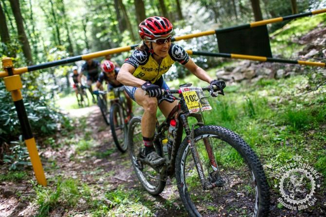 Cheryl Sornson leads a group under a gate and i nto a rocky Wert Path of Stage 6
