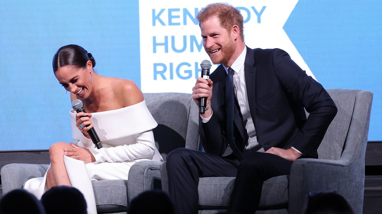 Prince Harry and Meghan Markle laugh onstage