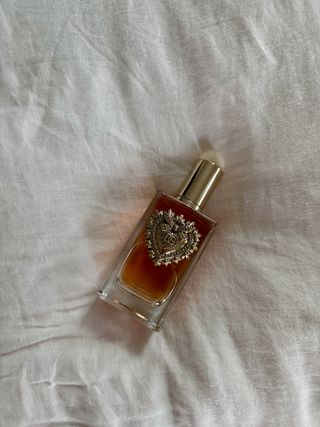 A bottle of Dolce & Gabbana Devotion perfume on a white background.