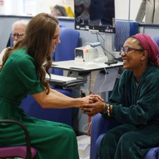 Princess Kate wearing a green dress and holding hands with a cancer patient