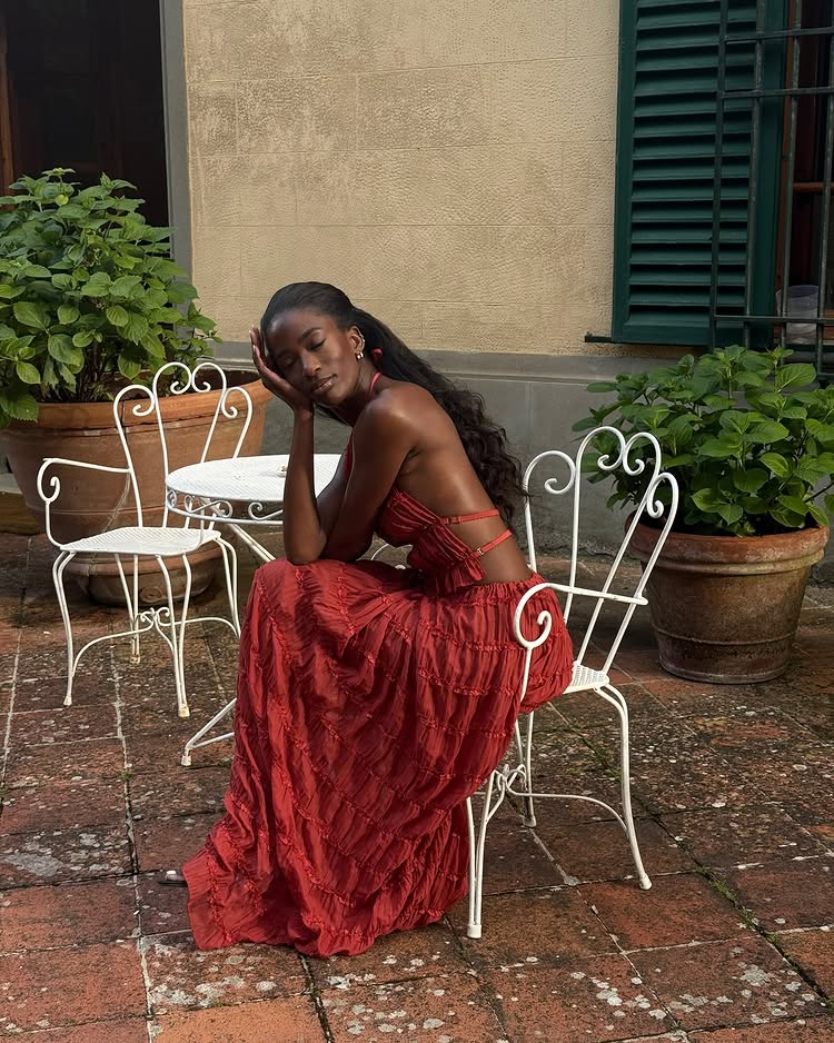 An image of @_livmadeline wearing a red halterneck dress while on holiday in Italy.