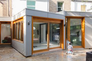 grey contemporary extension to terrace house with large glass doors designed to accommodate three generations