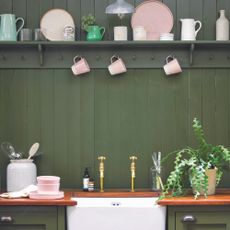 Kitchen with green wall panelling behind butler sink