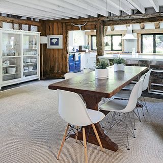dinning area with wooden diining table and white chairs and white storage unit