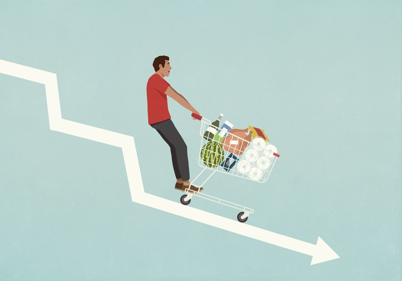 Male consumer with shopping cart of groceries falling down descending arrow