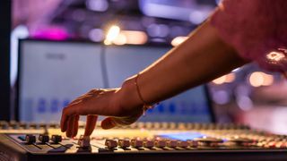 Audio engineer uses a mixing console for a live gig