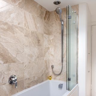 Folding bath and shower screen in beige bathroom