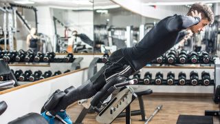 Man uses back extension machine in a gym