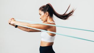 Do resistance bands build muscle? Image shows young woman using resistance bands