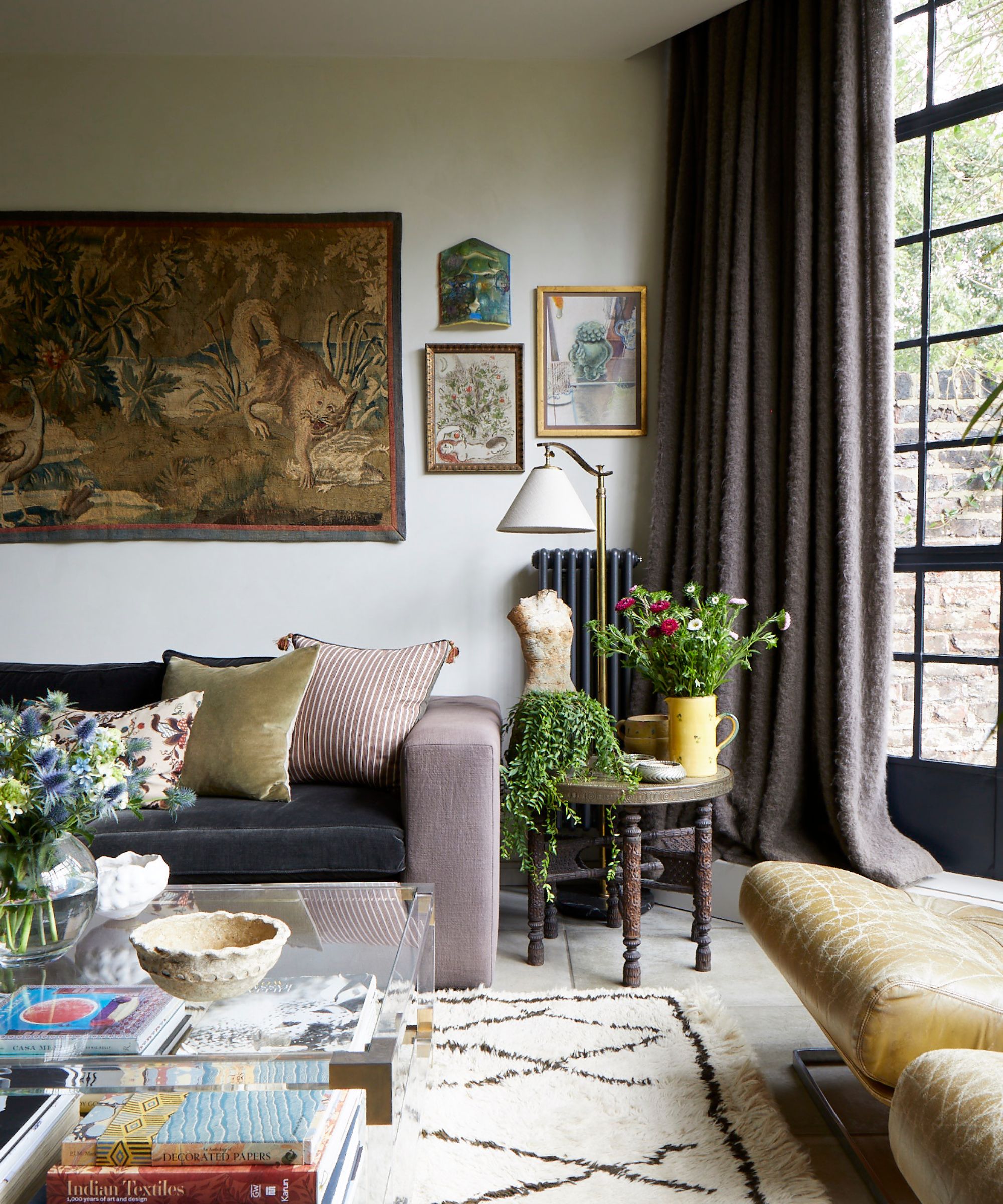 Living room with leather seats, velvet sofa and cushions and fluffy rug and tapestry hanging