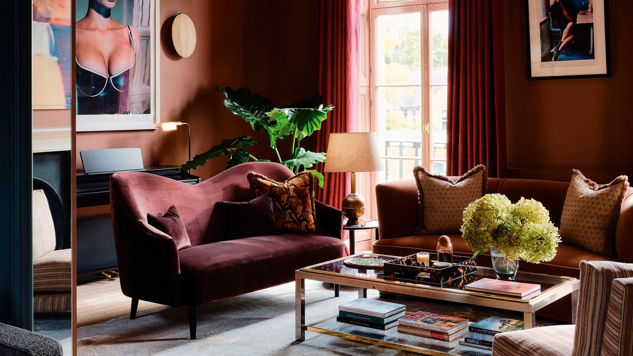 a dark red living room with red couch and styled coffee table