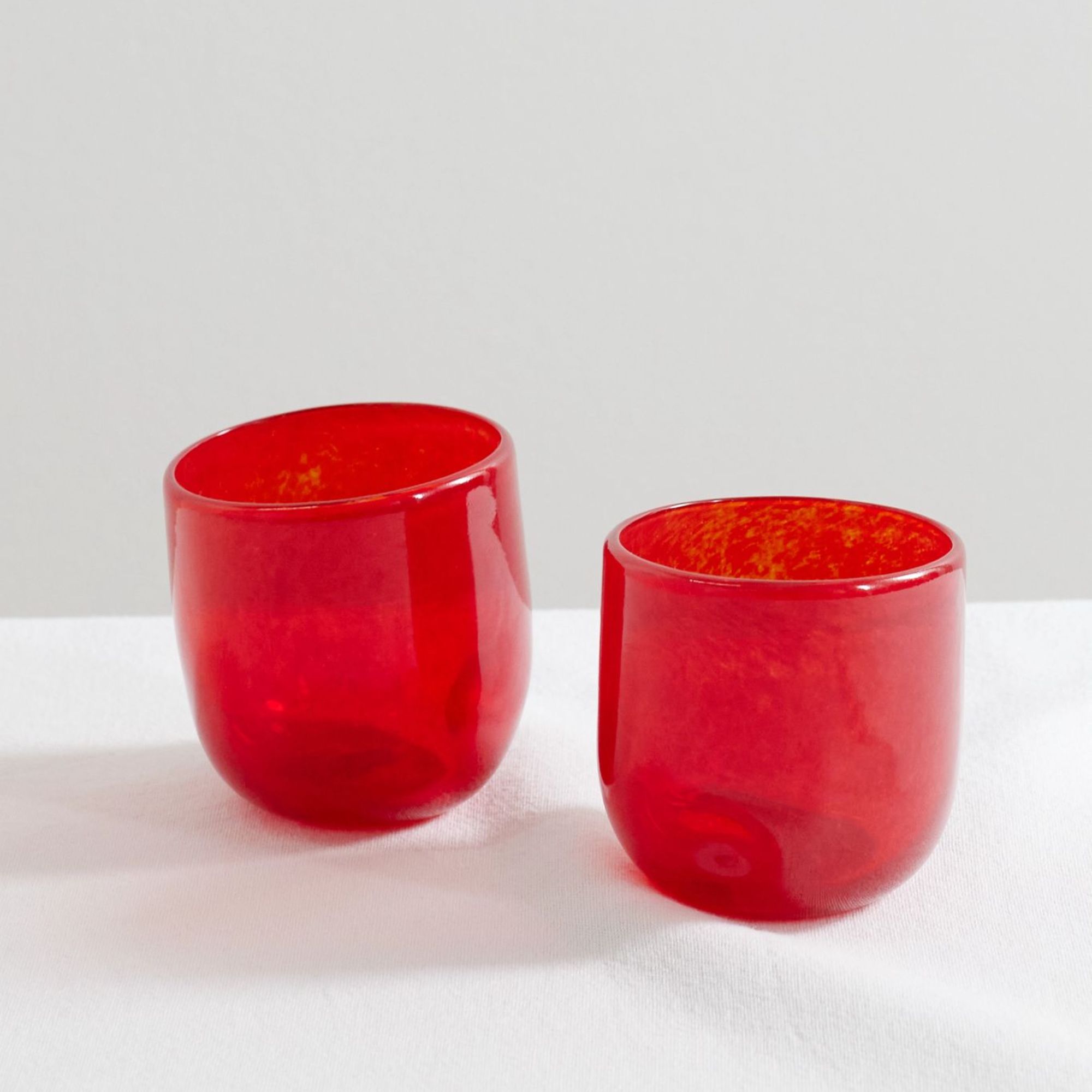 Two hand-blown red glasses