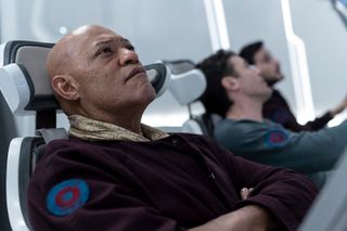 Three astronauts strapped into their spaceship cockpit chairs