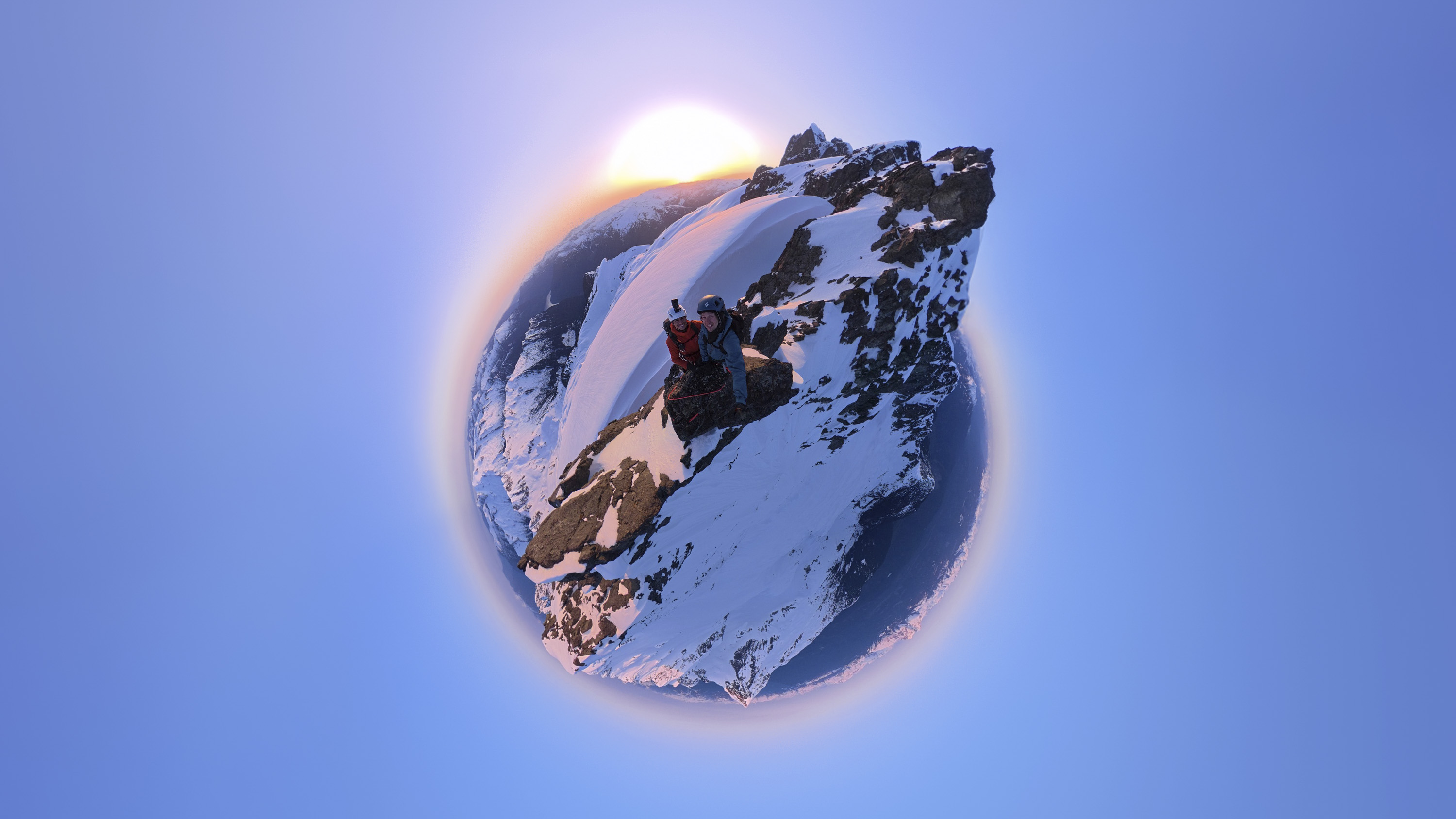 Tiny-planet-style photo of two hikers on a mountain summit, taken with the DJI Osmo 360 camera