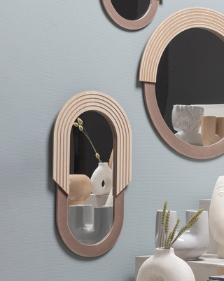 oval mirror with ridged wooden detail hanging on a wall