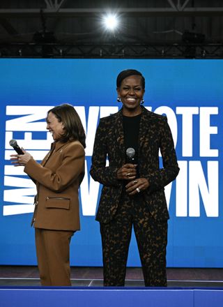 Michelle Obama appears at a Michigan rally with Kamala Harris wearing a tortoiseshell suit and silver earrings