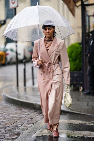 Maria Bernad wears a pink long coat, a Bottega Veneta cream color puff bag, a turtleneck brown dress, during Paris Fashion Week