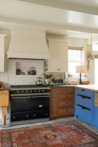 Blue shaker kitchen with range cooker and red rug