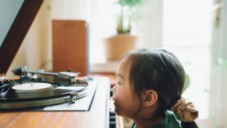 Child watching a vinyl record played on a turntable