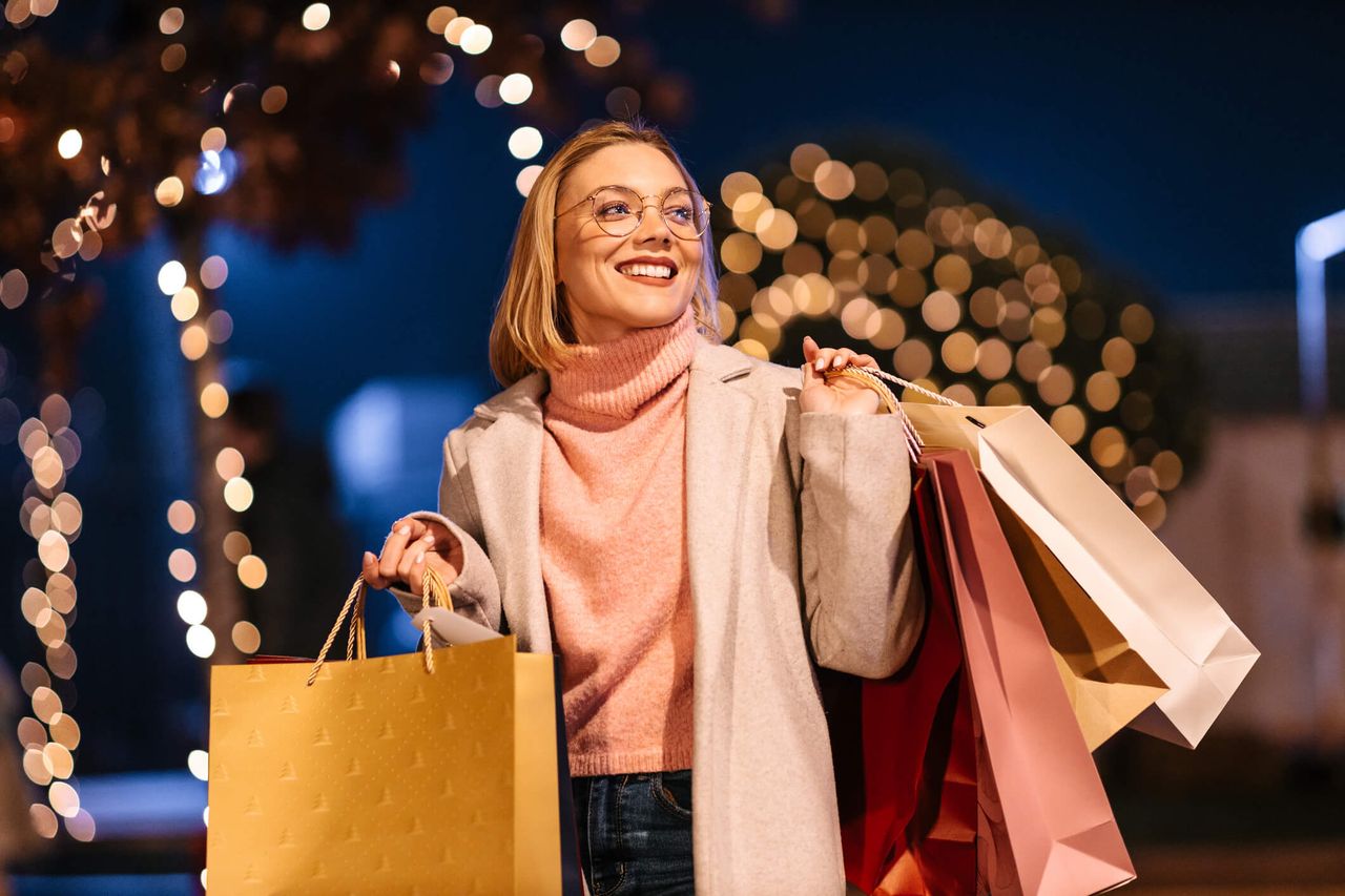 A young blondie after Christmas shopping with a lot of bags. Happy and satisfied. Buying gifts. On sale