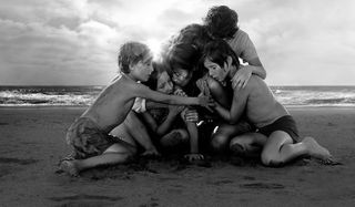 family huddling on beach in Roma