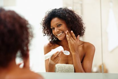 Woman looking at age spots in mirror