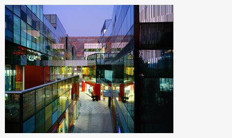 View of The Village at Sanlitun by Swire Properties - colourful glass front buildings with a path in the middle