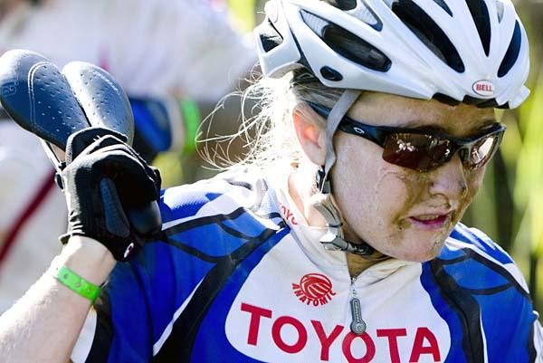 A woman carries her bike.