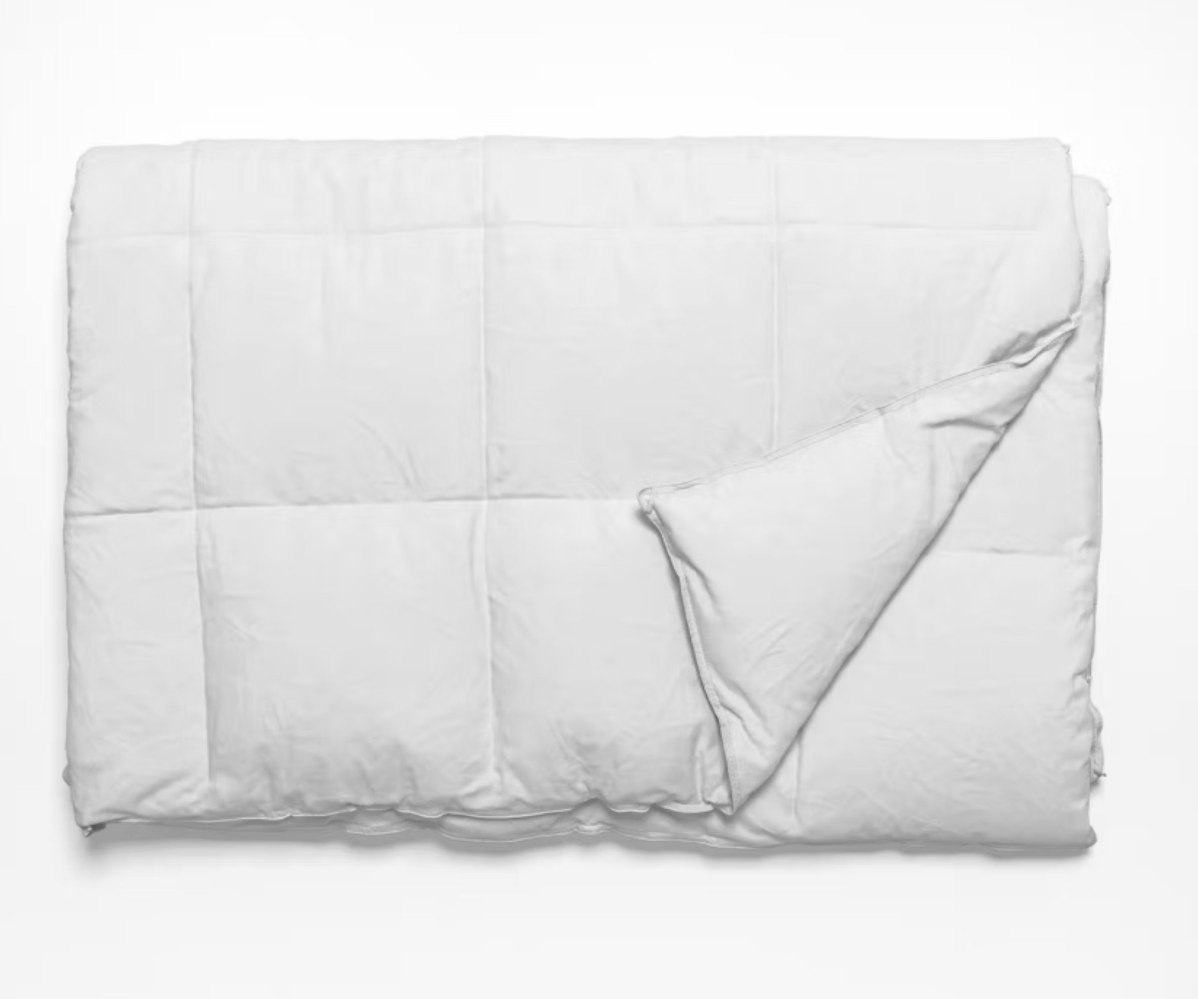 The Saatva Down Alternative Comforter folded in half with one corner flipped over