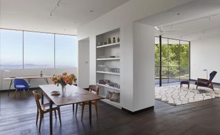 Wall-length windows create the illusion of a much larger space opening the house outwards into the dramatic surroundings
