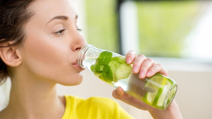 Close up woman drinking bottle of cucumber water