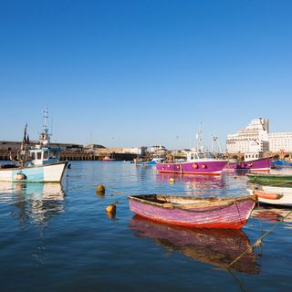 Harbour with different colour boats and blue sky