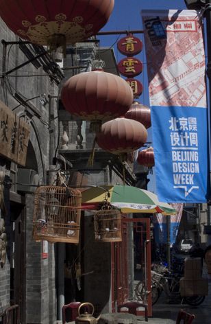 View along a street with hanging bird-cages, lanterns and banners for Beijing Design Week 2013