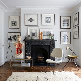 fire place with white wall frames white chair and wooden flooring on wall