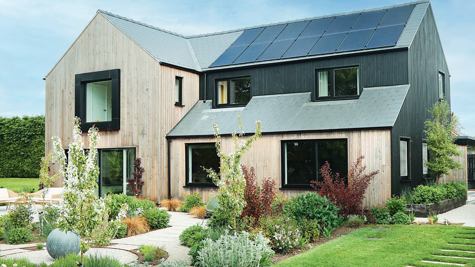 contemporary home with external timber cladding and solar panels on roof