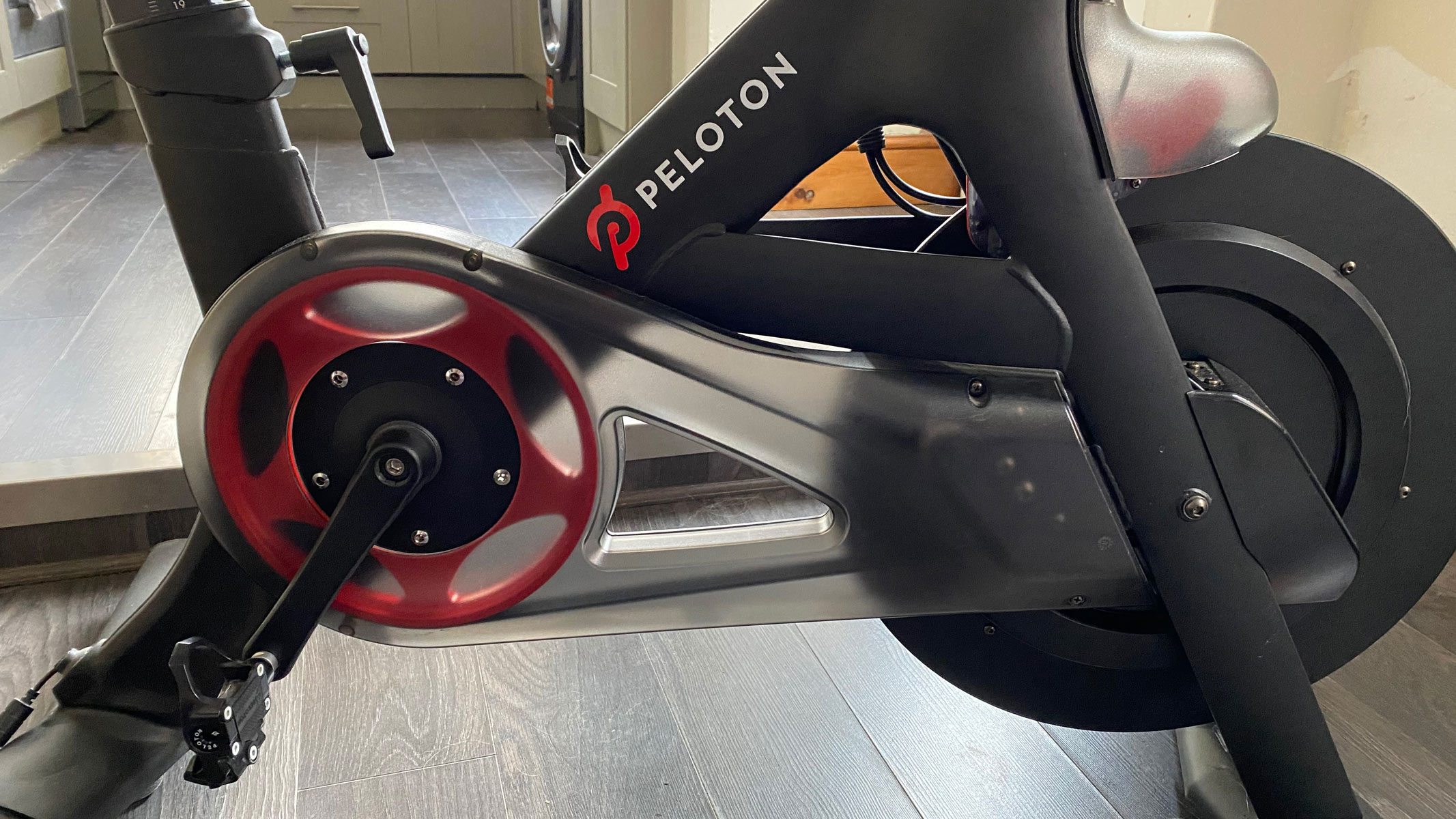 A close-up picture of the pedals and flywheel on the Peloton bike