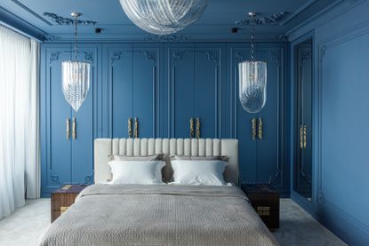A blue and white bedroom with blue painted walls and white bedding