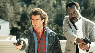 A still from the first Lethal Weapon movie showing Mel Gibson and Danny Glover with their guns out. That's real guns, not biceps.