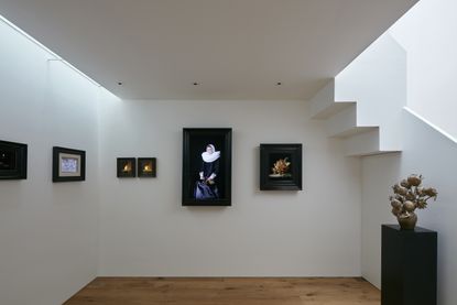 White walls with various pieces of art in black frames