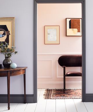 lilac living room with gray woodwork, pink hallway, white floor boards, rug, console table, artwork