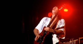 Pat Travers takes a solo under a red stage light in Chicago